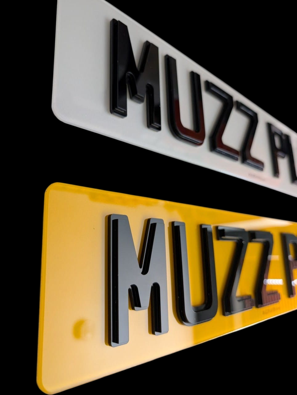 Two obsidian number plates with 'MUZZPLATES' branding on a black background